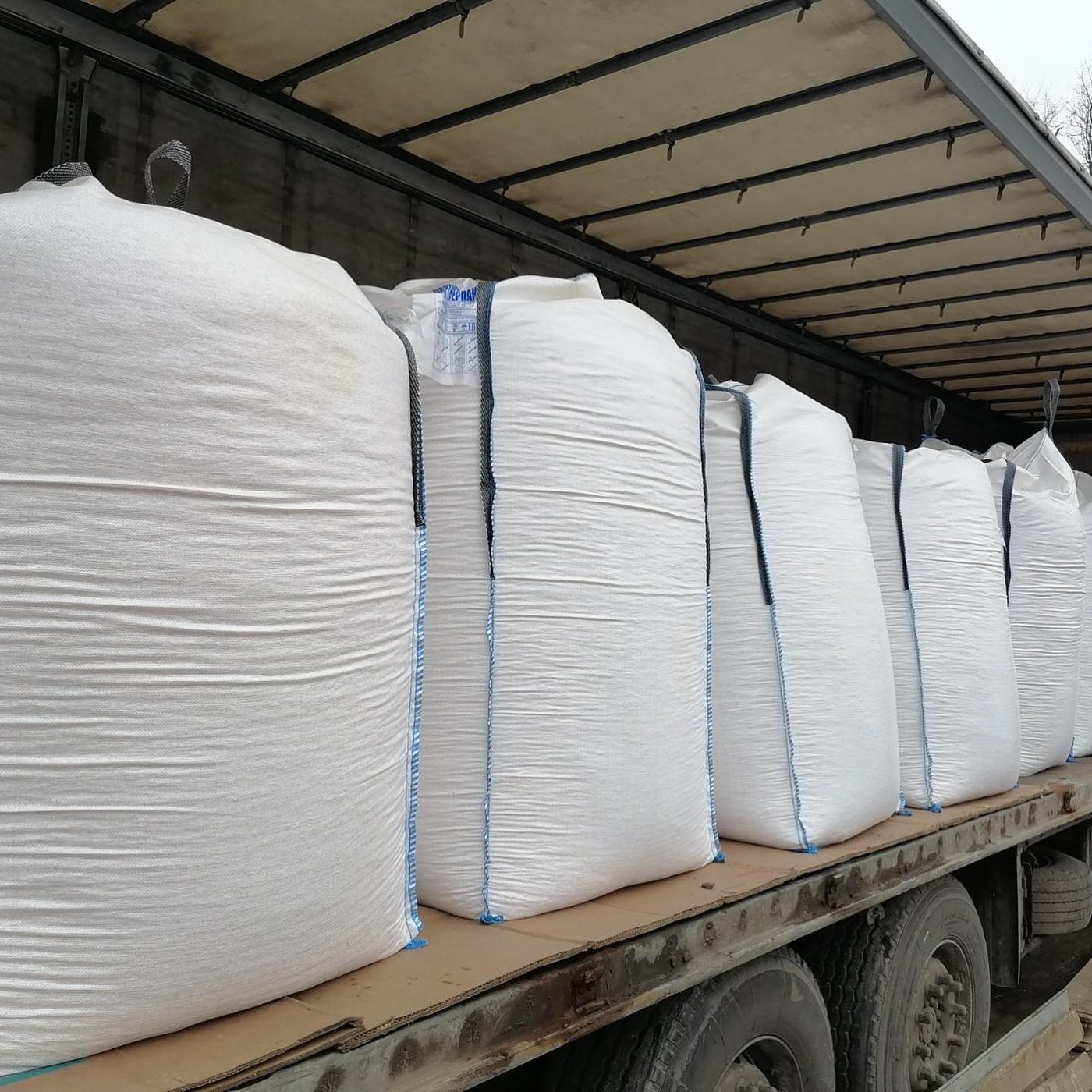 Row of trucks loaded with bulk wood pellet bags for European delivery